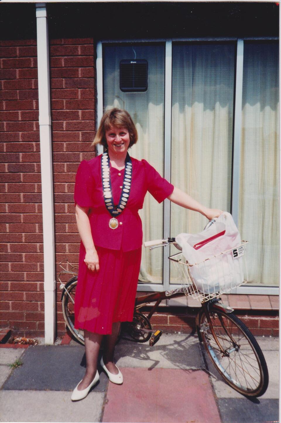 A woman wearing all red next to a bike