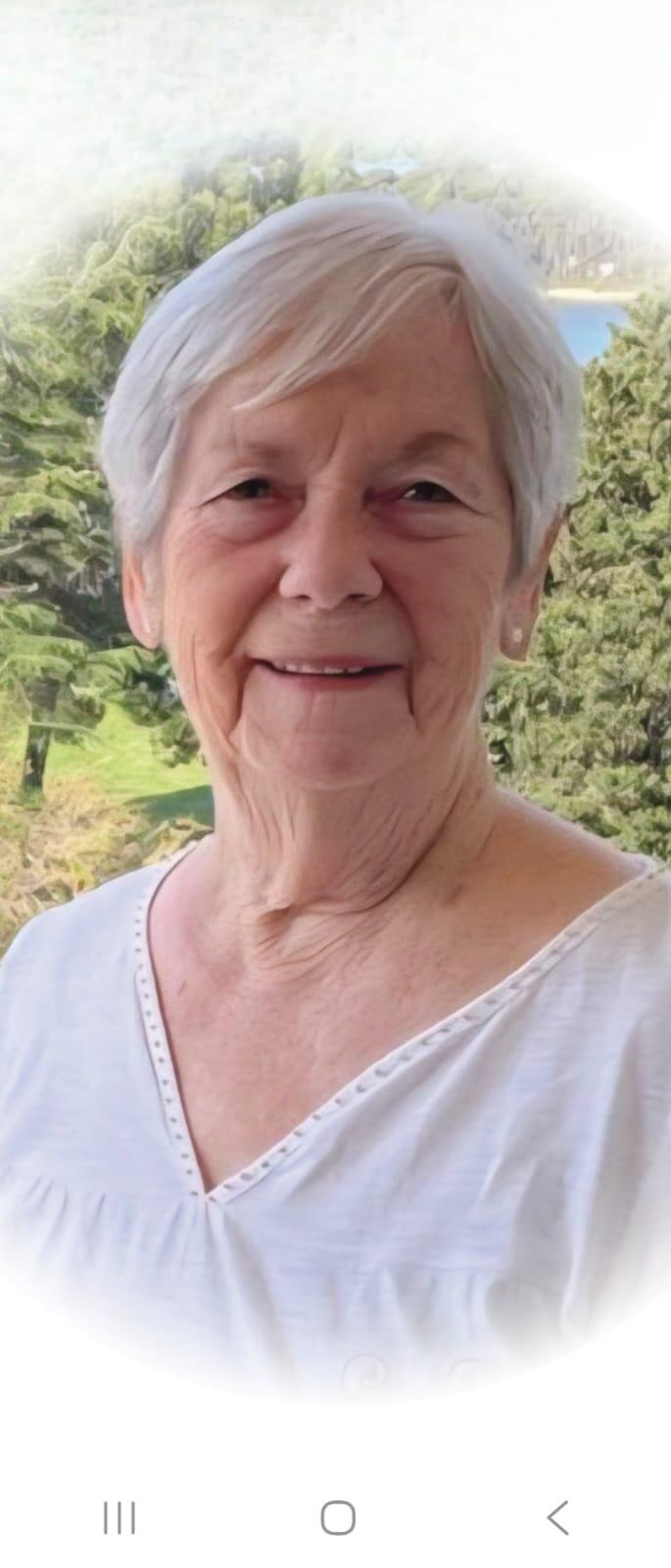 A woman with short white hair wearing a white top