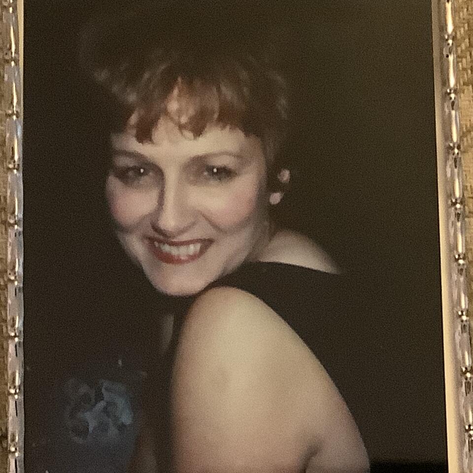 A woman smiling while looking over her shoulder