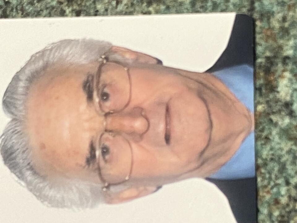 A man with white hair and glasses