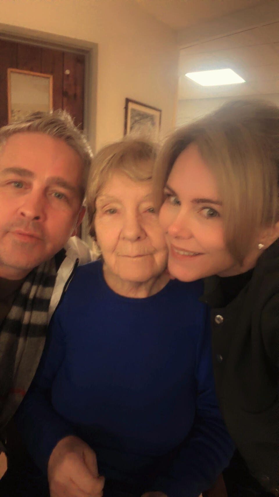 A man with grey hair, an older woman with short blonde hair and a purple top and a woman with blonde hair in an up do wearing a black top