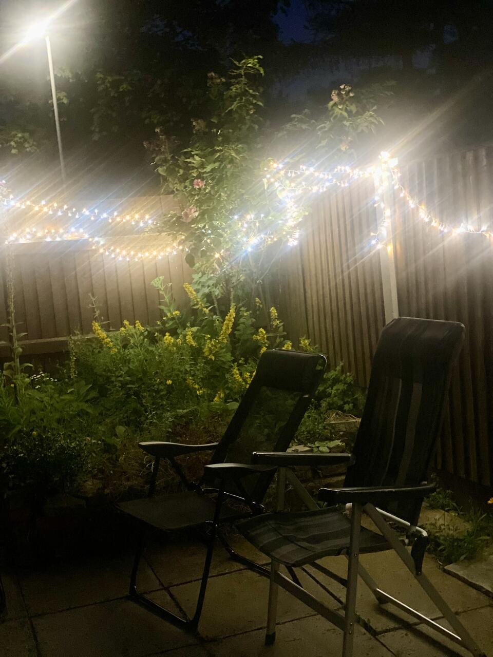 Fairy lights and two chairs in a garden