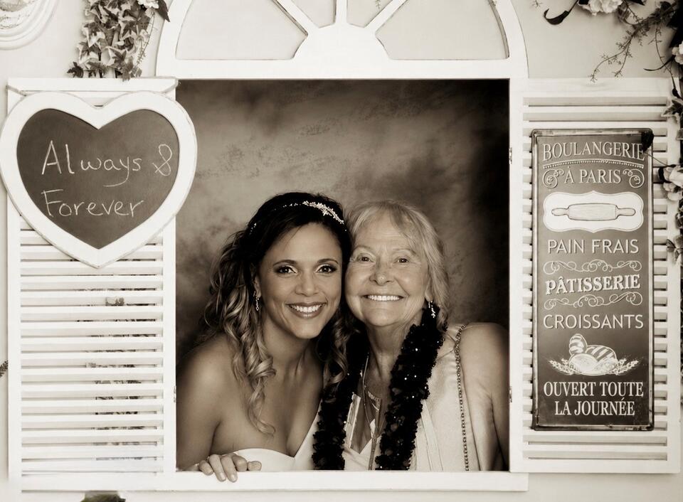 A sepia photos of a bride and older woman in a window