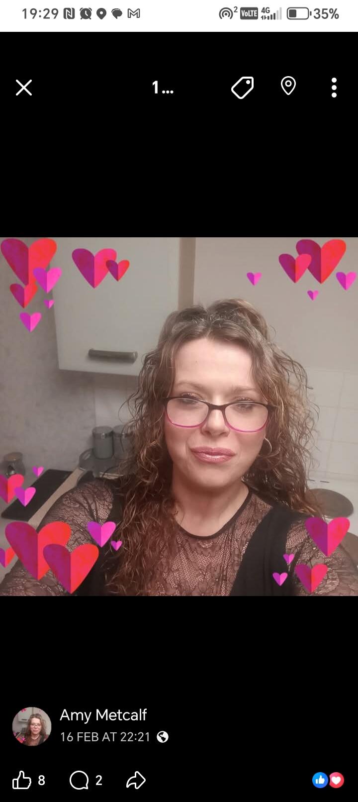 A lady wearing glasses taking a selfie surrounded by cartoon hearts