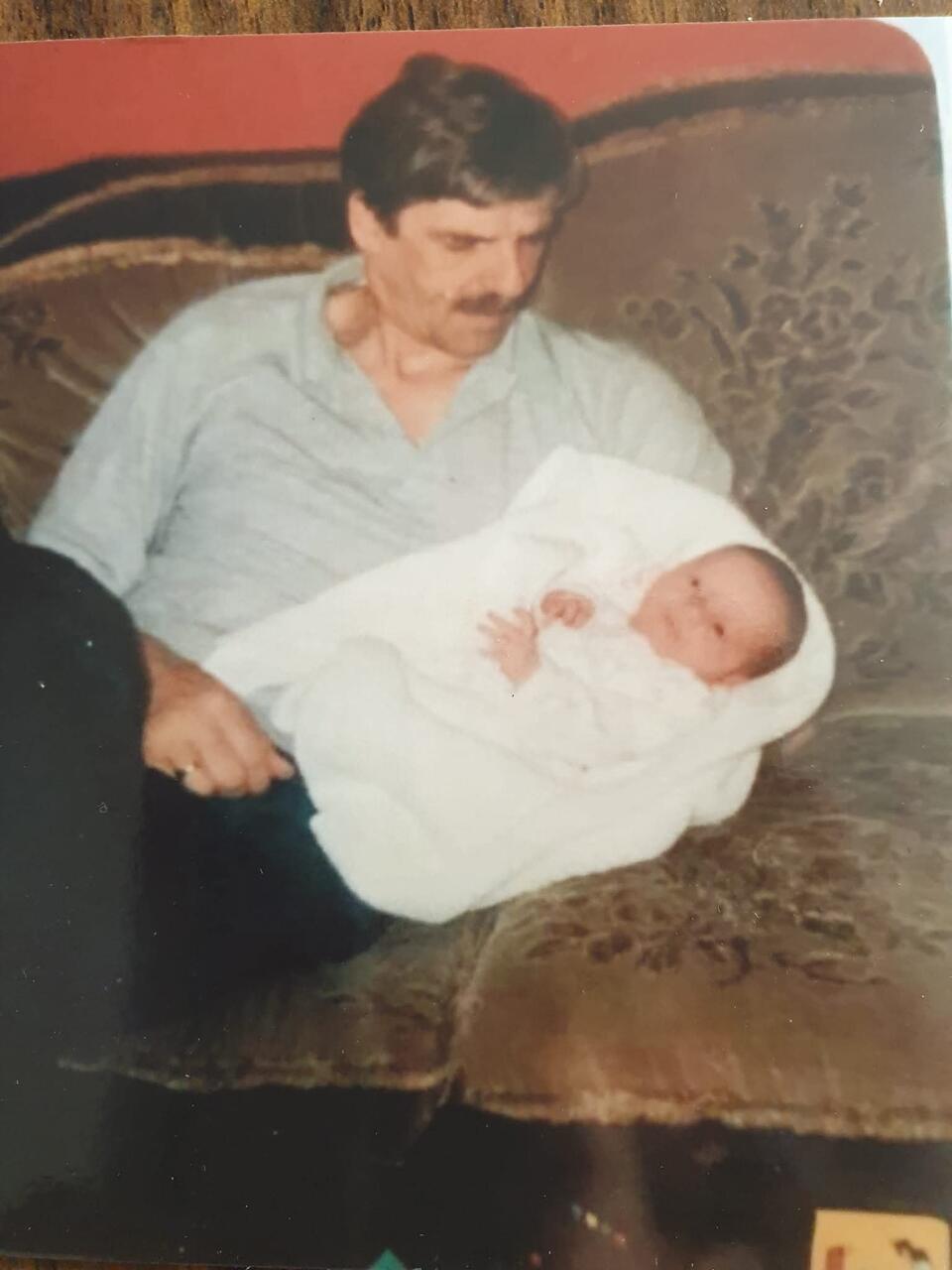 A man on a sofa holding a baby