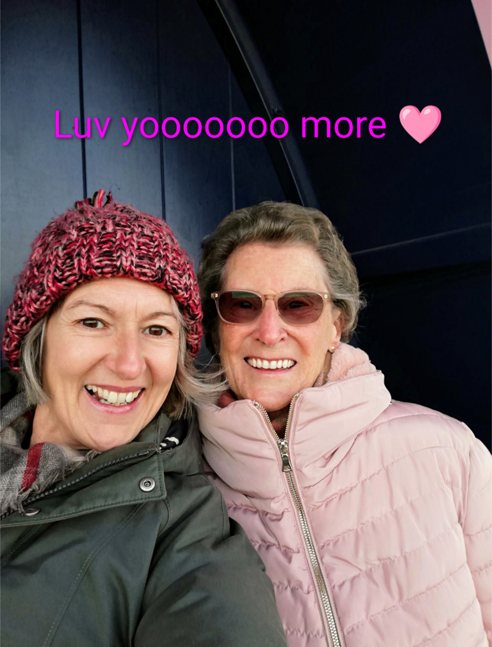 A selfie of two smiling women in coats