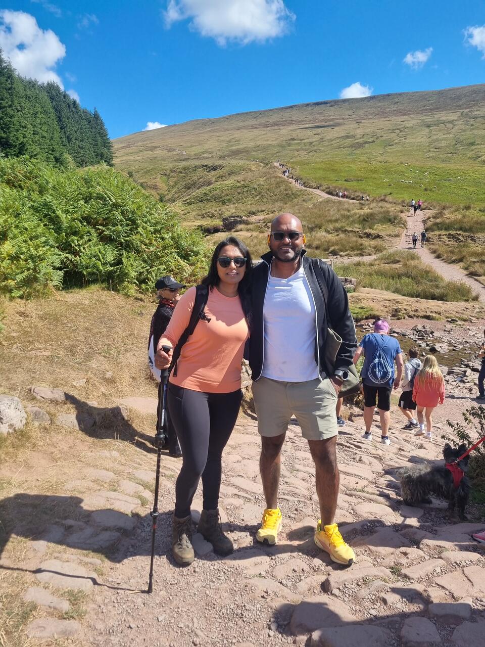 Two people stood on a hilly trail