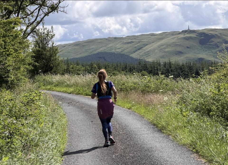 A woman running on a countryside road