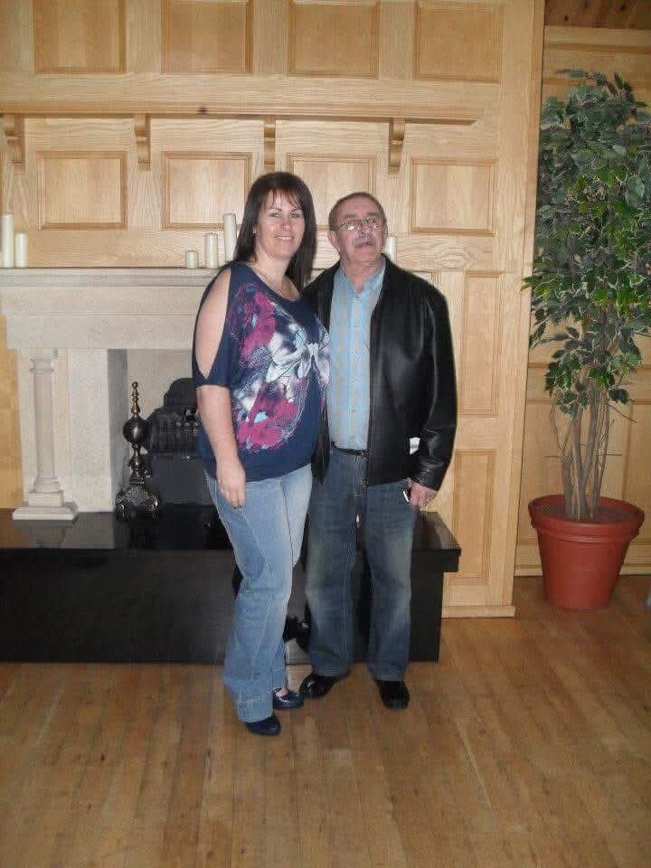 A woman with short brown hair and a man with glasses stood together and smiling