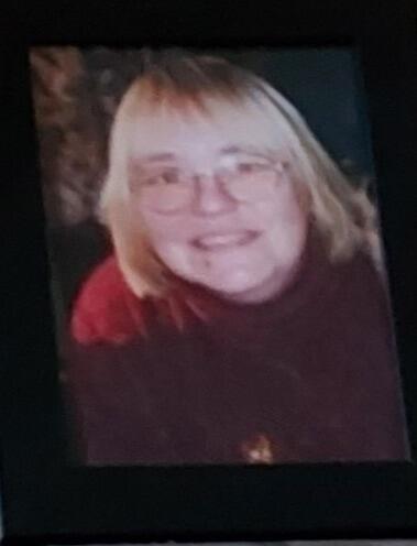 A woman with a blonde bob and red top