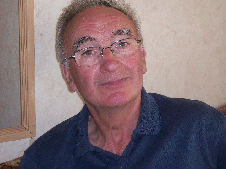 An older man with a glasses and a blue shirt