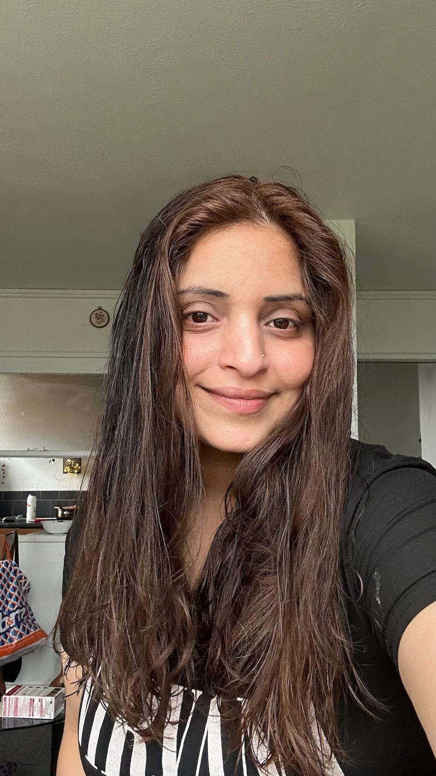 A selfie of a smiling woman with long brown hair 