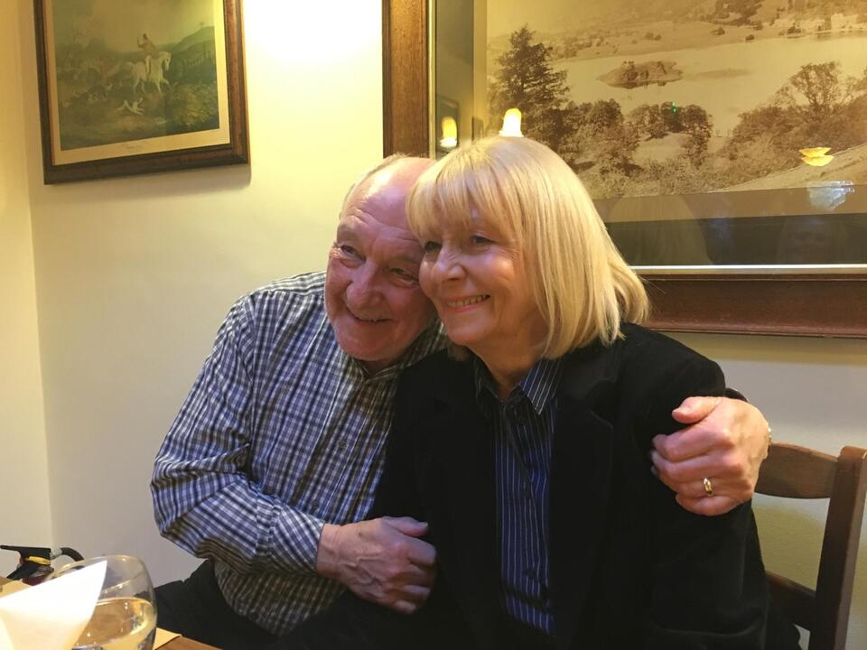 A man hugging a woman at a table