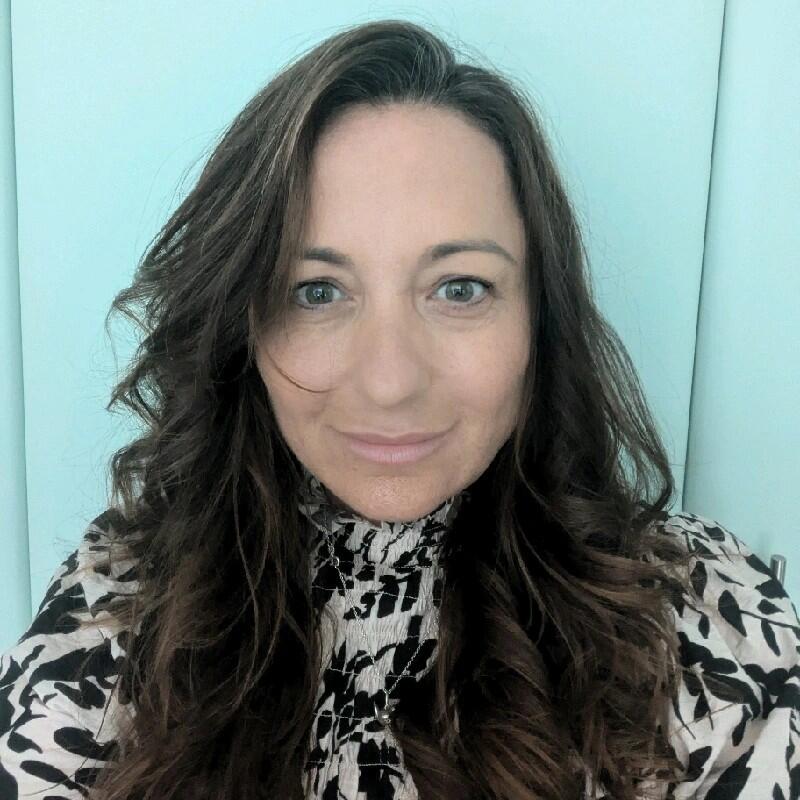 A selfie of a woman with long brown hair