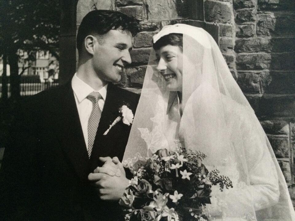 A black and white photo of a smiling groom and bride