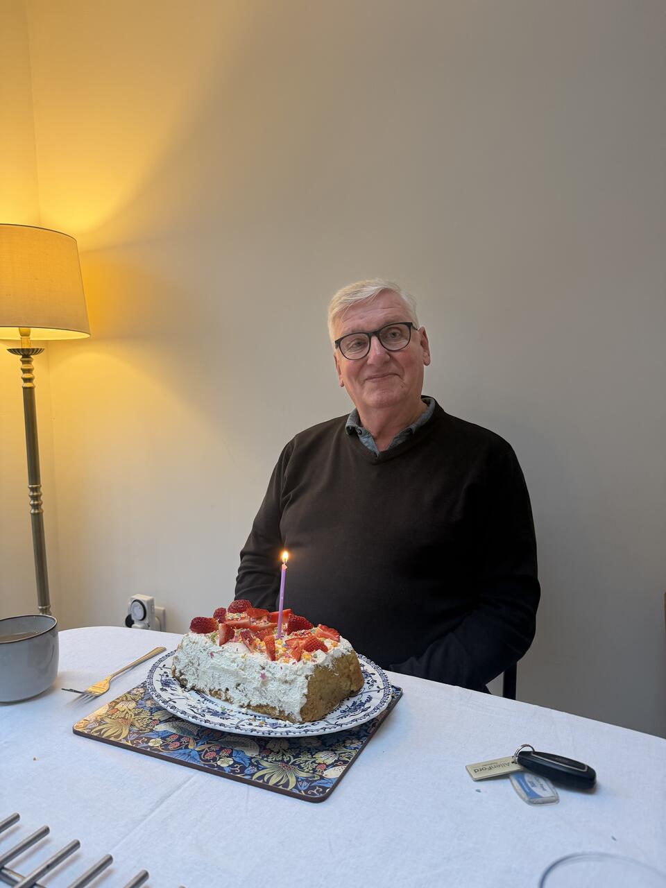 A man sat at a table with a cake