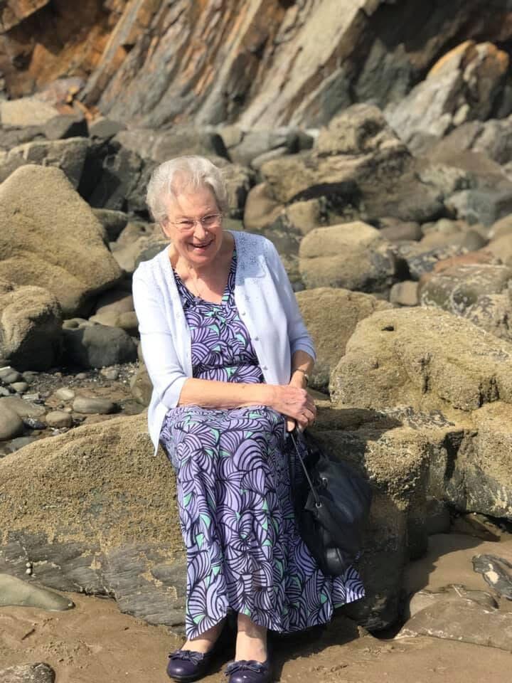 A woman sat on a rock on a beach