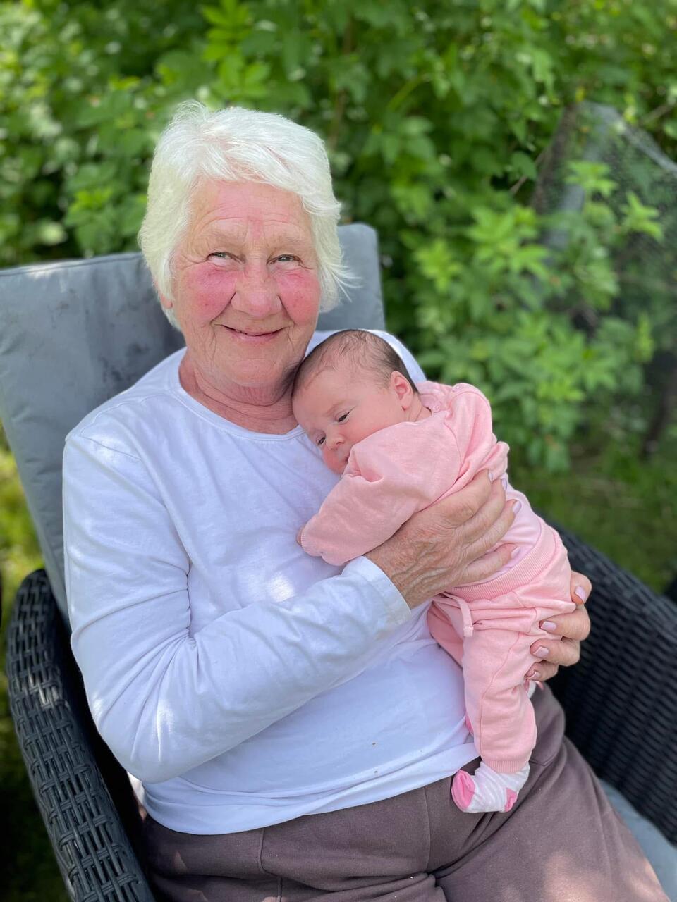 A woman sat in a chair holding a baby