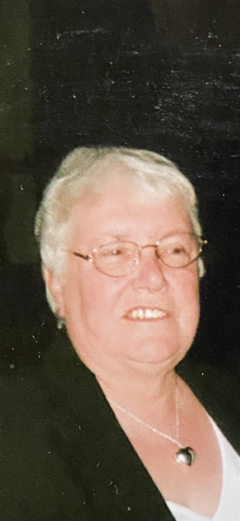 An older woman with short white hair and glasses