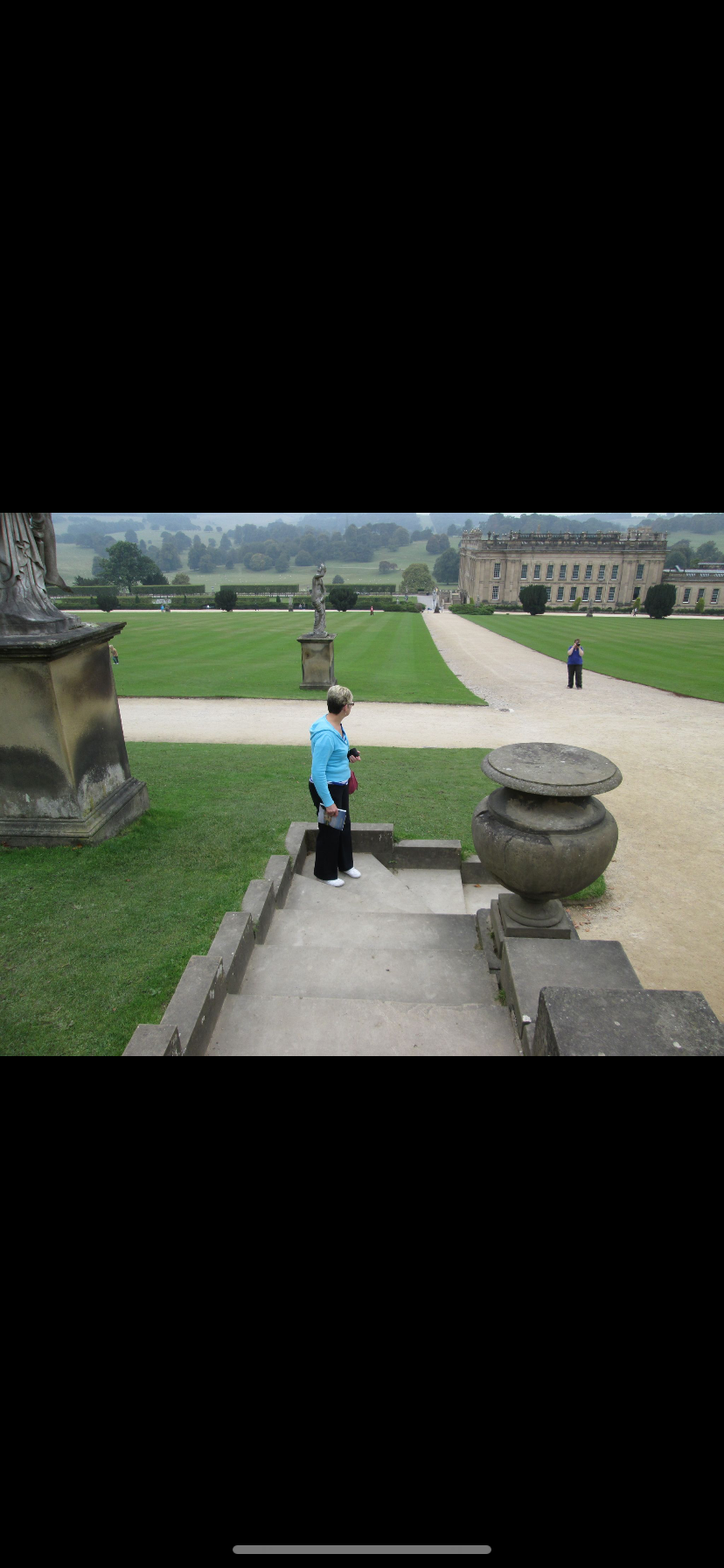 A woman wearing a blue top in a country estate