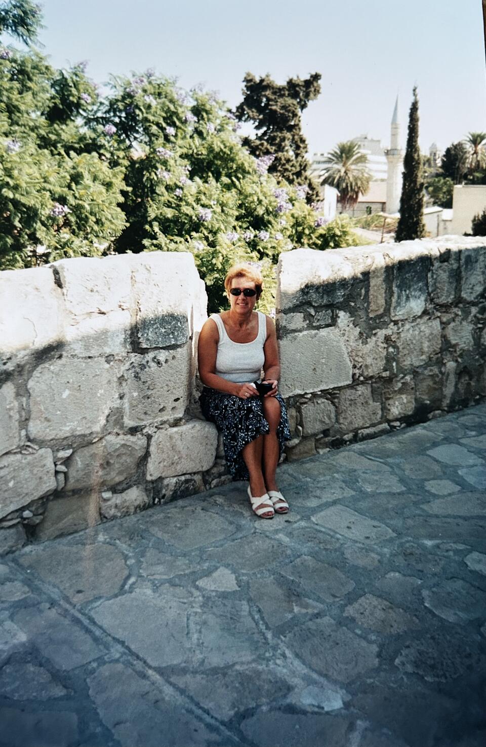A woman sat on a stone wall