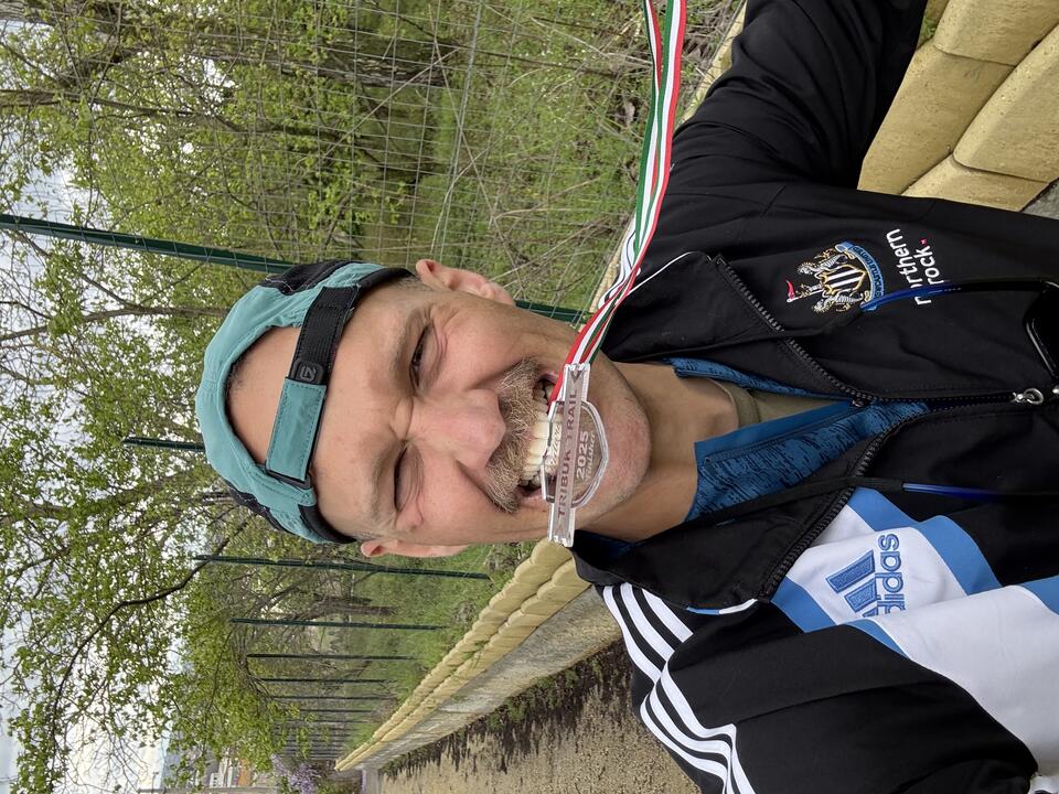 A man with a backwards green cap and an navy Adidas jacket