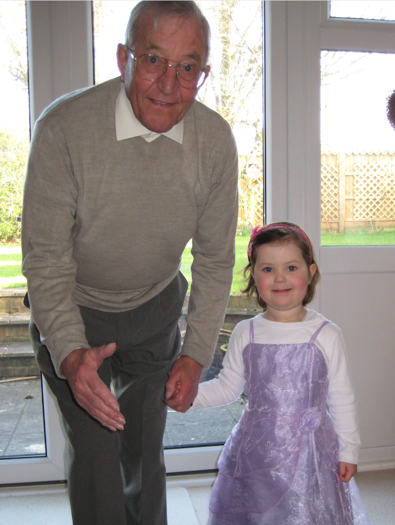 A man leaning towards a camera holding a young girl's hand