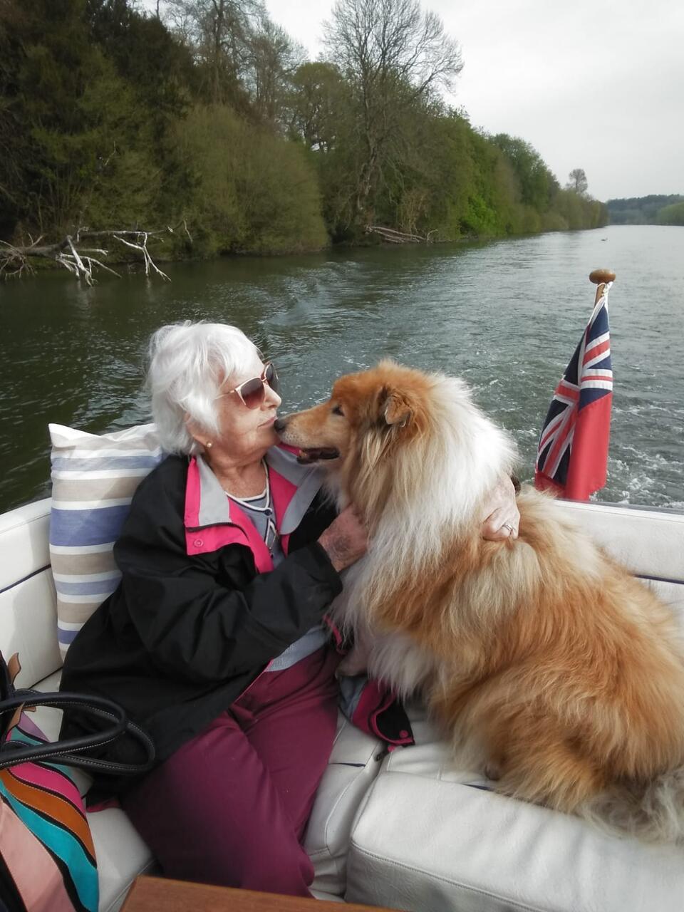 A woman with a dog on a boat on water