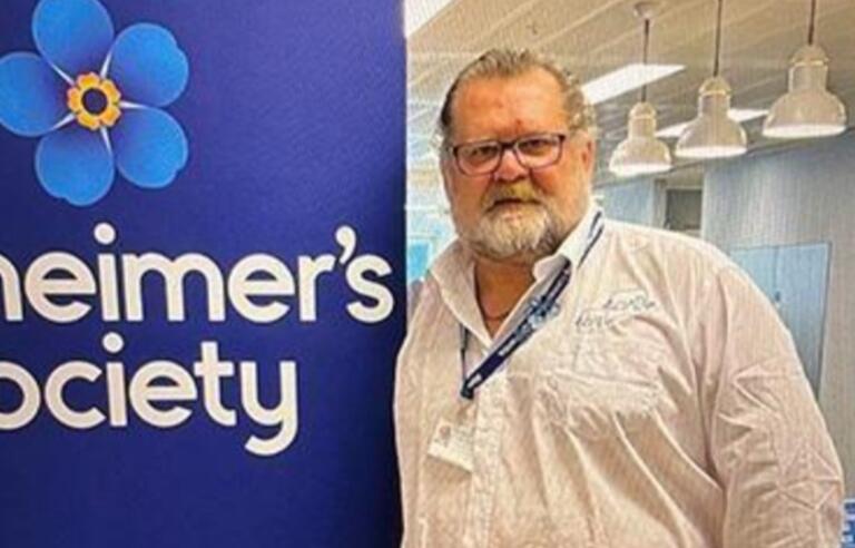 Paul Harvey in the office next to Alzheimer's Society signage