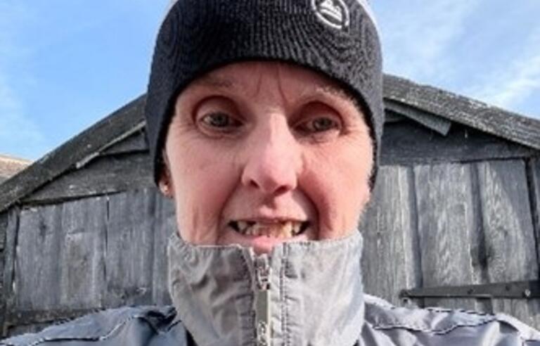 A selfie of Gill Ashington outdoors with a zipped up coat and beanie hat on