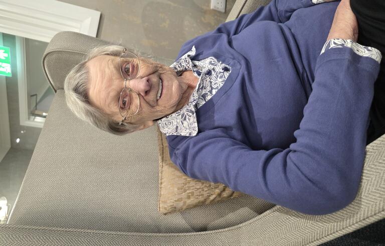 An older woman sat in a large armchair