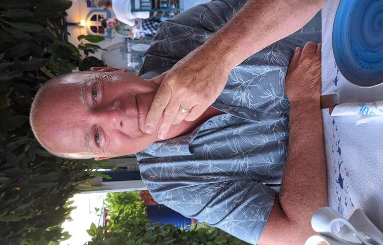 A man wearing a light blue shirt sat at a table