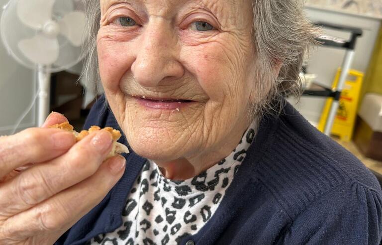 A woman with short grey hair, leopard print top and navy cardigan 