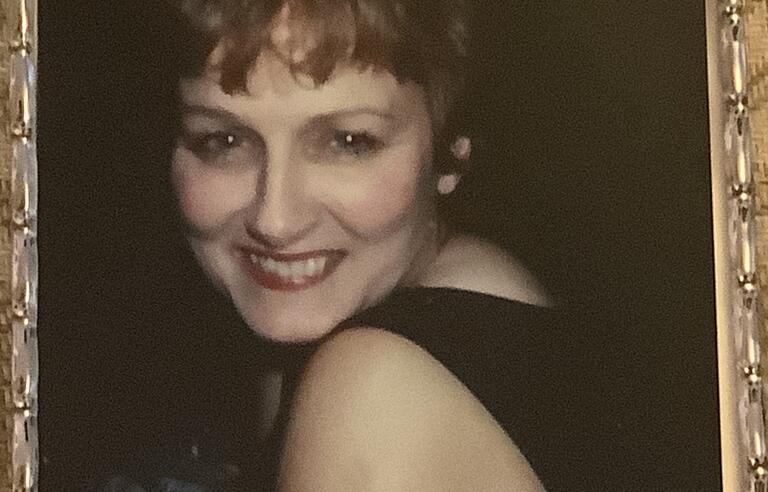 A woman smiling while looking over her shoulder