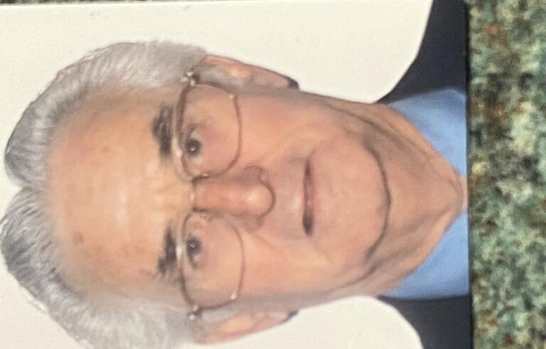 A man with white hair and glasses