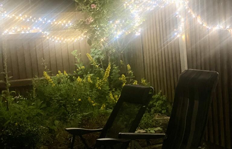 Fairy lights and two chairs in a garden