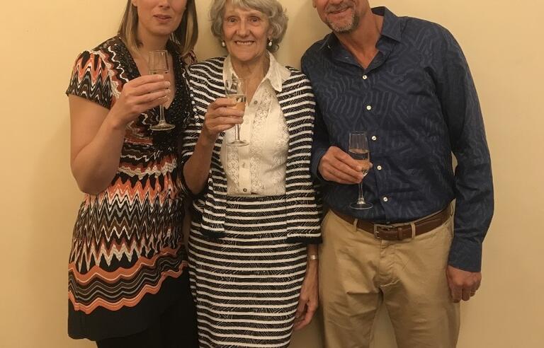 Two woman and a man holding wine glasses