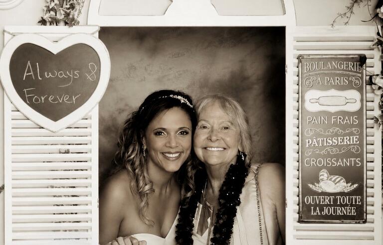 A sepia photos of a bride and older woman in a window