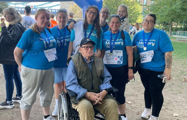 A man in a wheelchair surrounded by five people in Alzheimer's Society t-shirts
