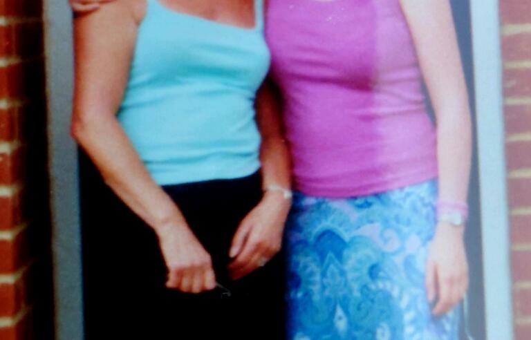 A woman with her arm around another woman