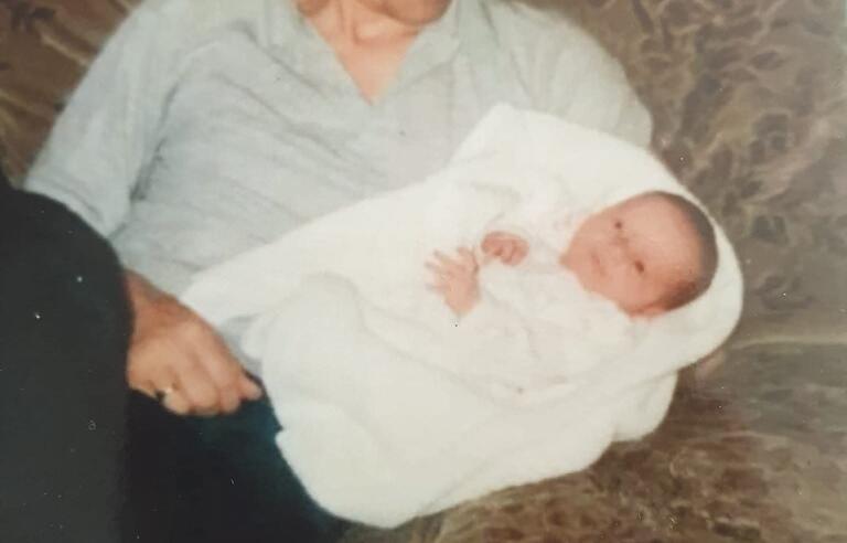 A man on a sofa holding a baby