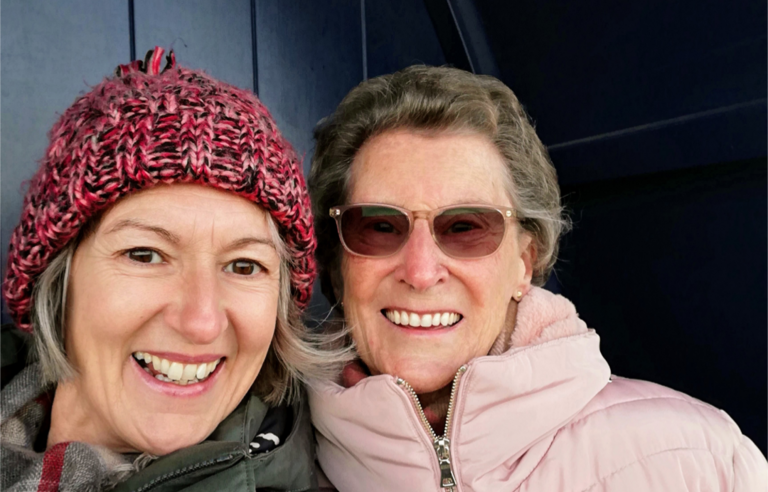 A selfie of two smiling women in coats