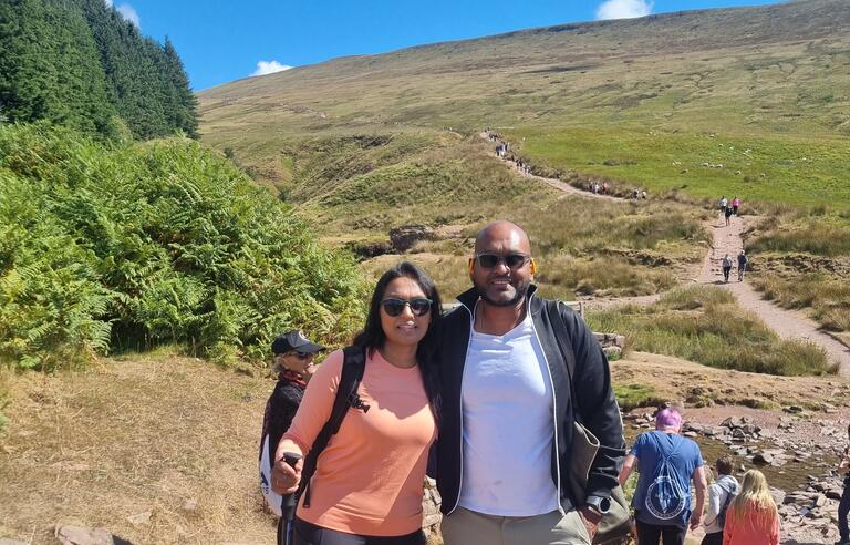 Two people stood on a hilly trail