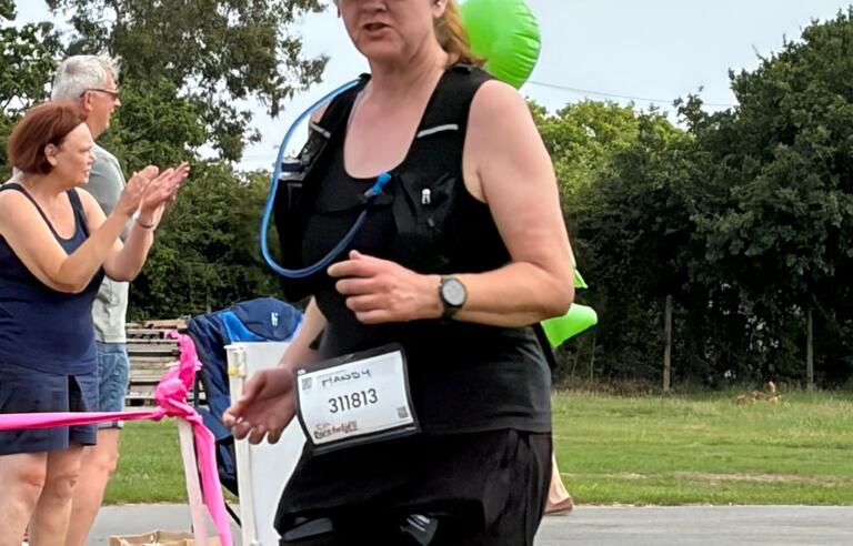A woman in sports gear running on grass