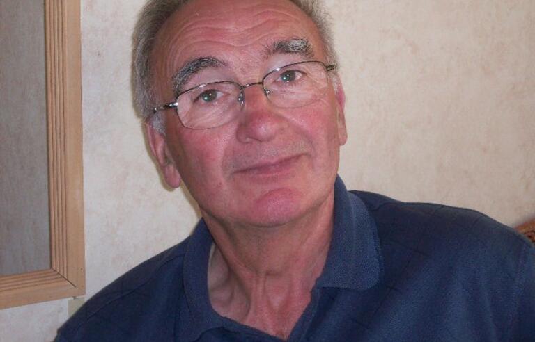 An older man with a glasses and a blue shirt