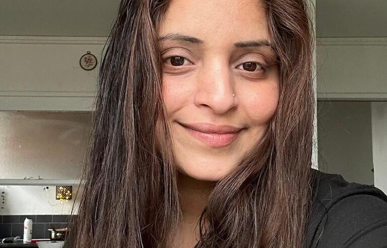 A selfie of a smiling woman with long brown hair 