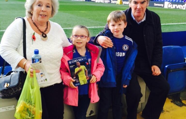 An older man and woman with a girl and boy at a football stadium