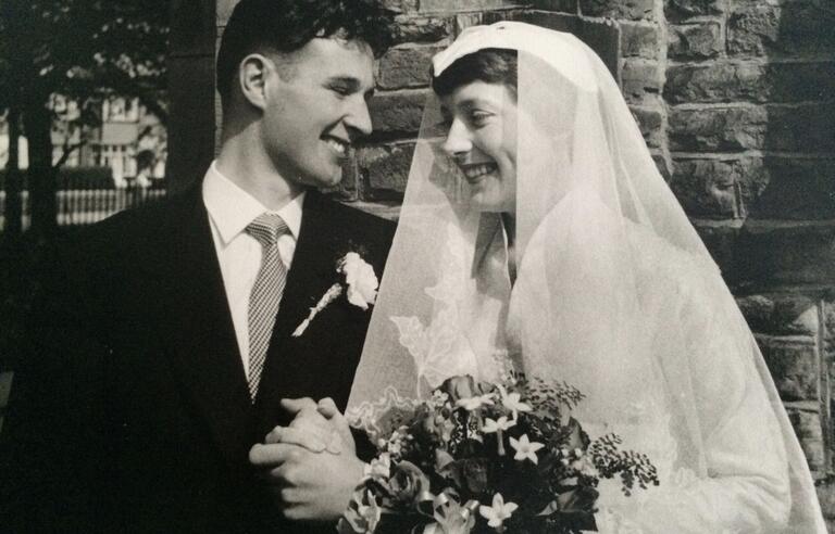 A black and white photo of a smiling groom and bride
