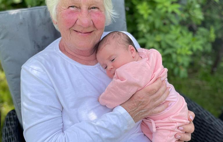 A woman sat in a chair holding a baby
