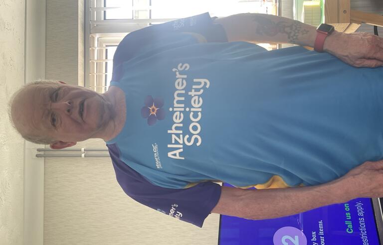 A bald man wearing a blue Alzheimer's Society top 